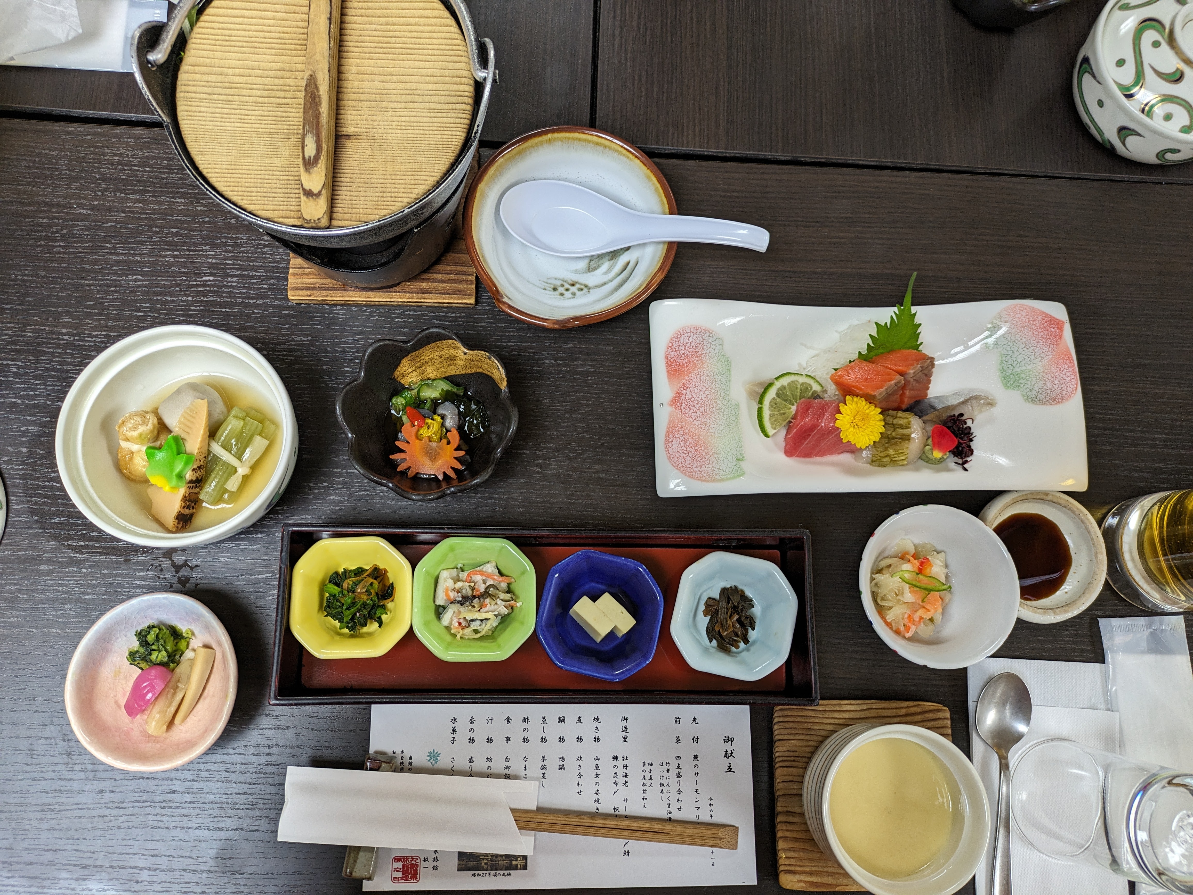 A colorful shot of small dishes with various bites contained therein.