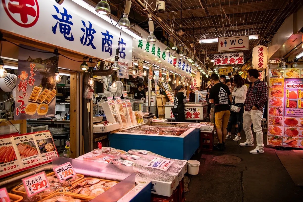 Visitors shopping at the Sankaku Seafood Market in Otaru, Hokkaido - How much does it cost to travel in Hokkaido?