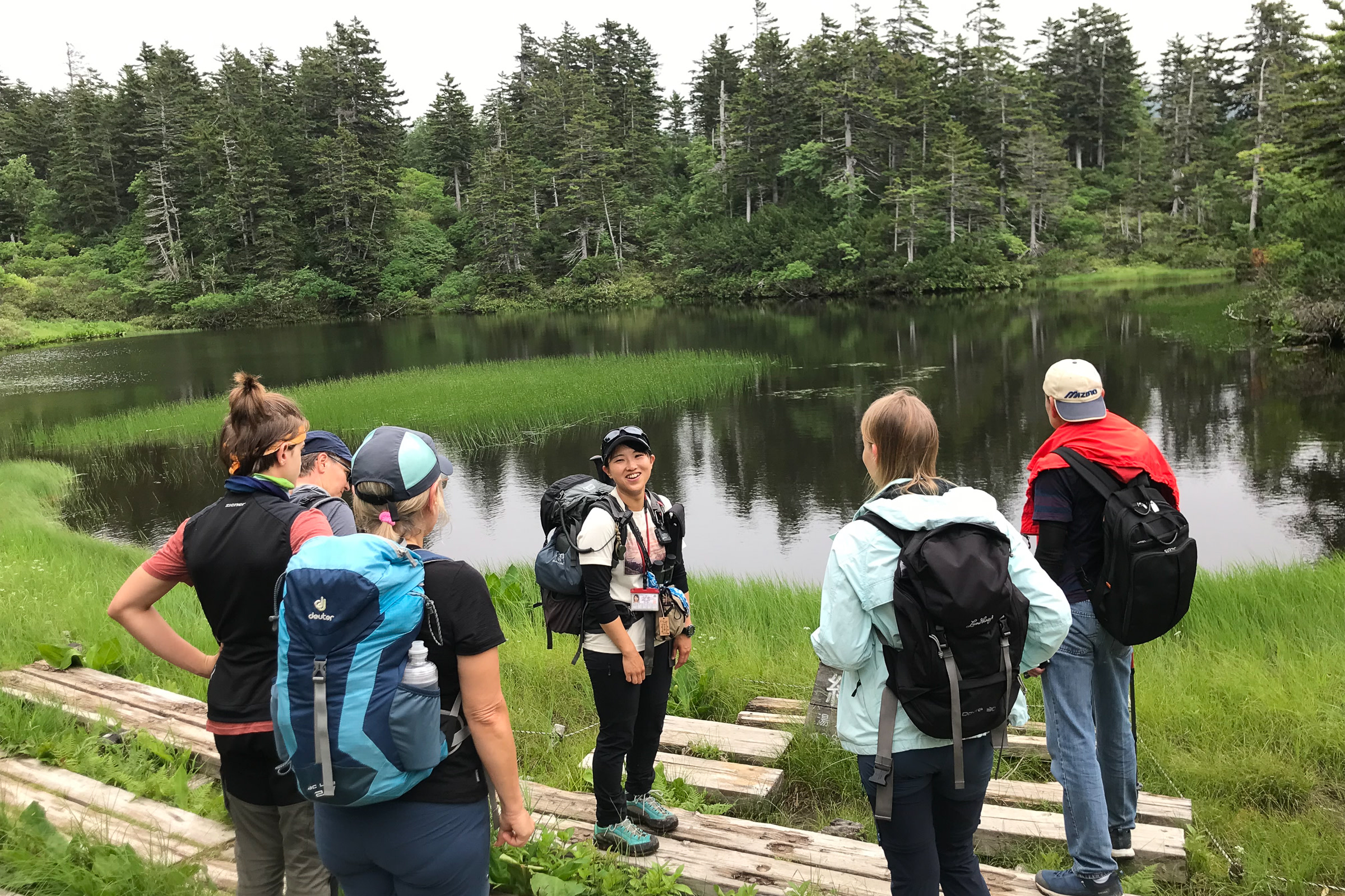 Adventure Hokkaido guide Yuka smiles as she is surrounded by our guests in front of Midori Pond at Daisetsu Kogen.