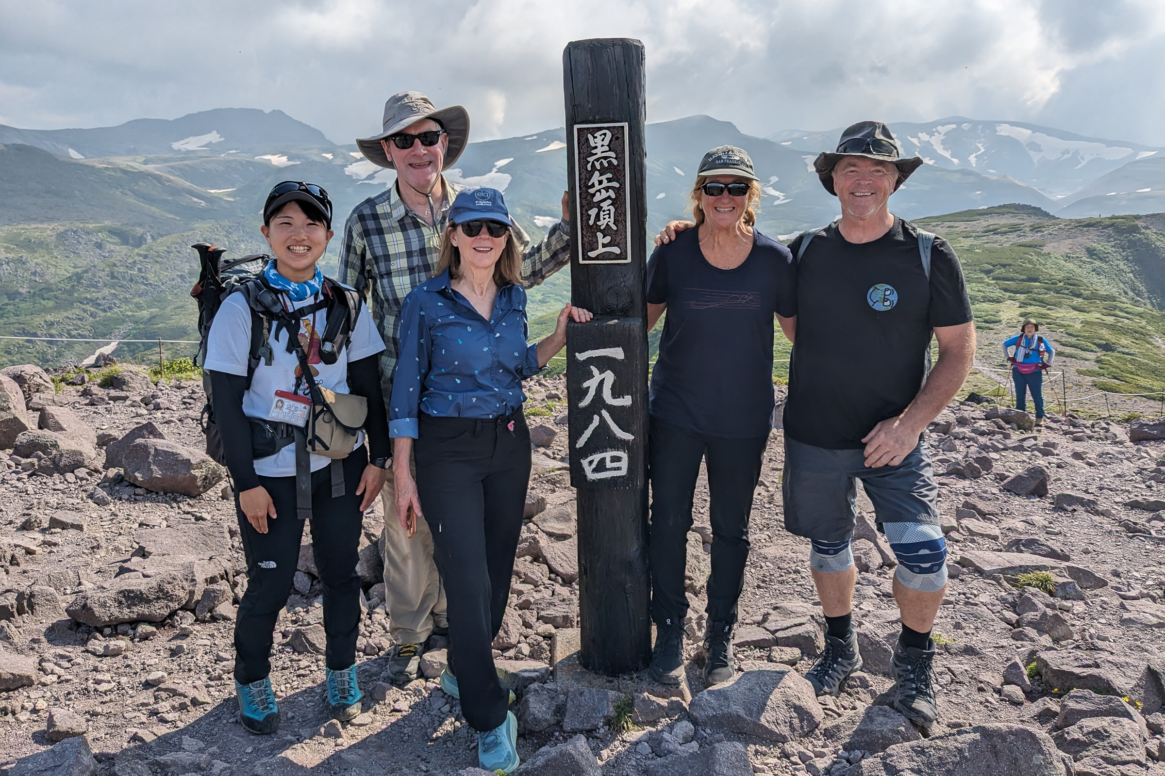 Adventure Hokkaido guide Yuka smiles with guests at the summit of Mt. Kurodake after a long traverse!