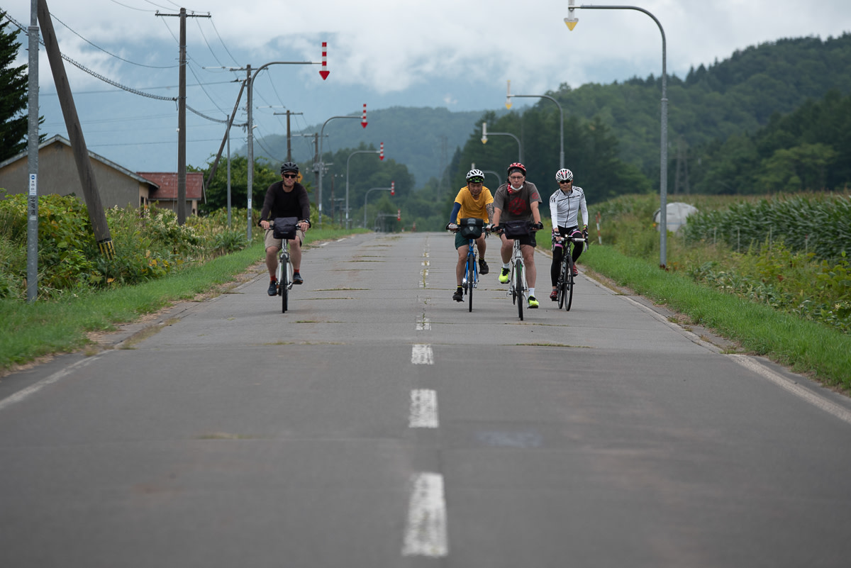 A group of cyclists ride straight towards the camera