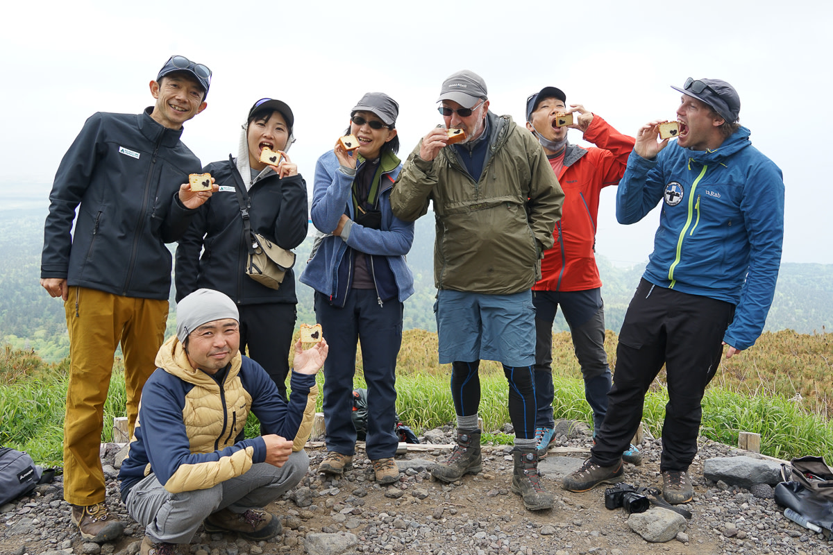 A group of hikers pose with cake on Mt Rishiri