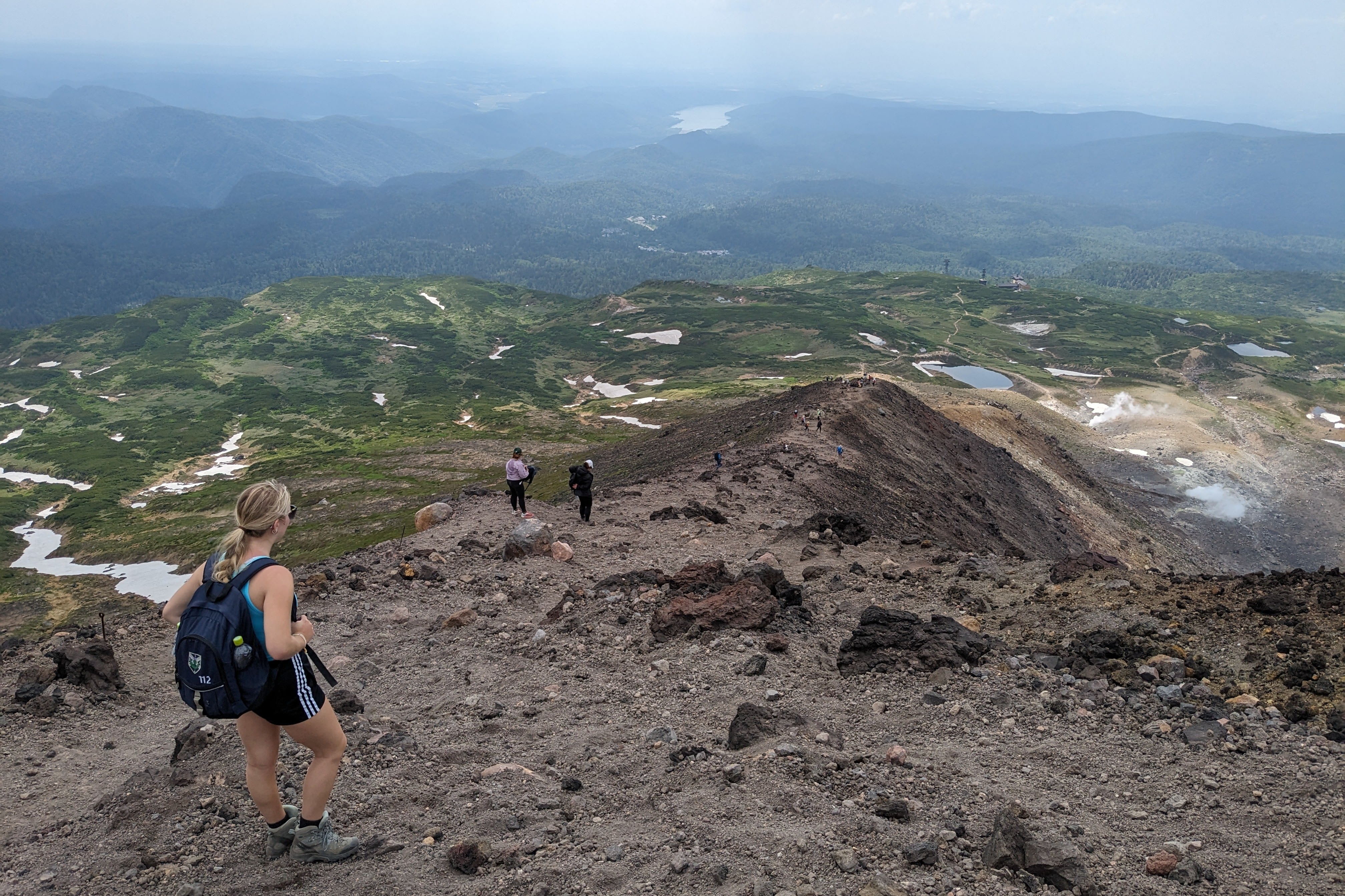 A family descends the rocky slopes of Mt. Asahidake.