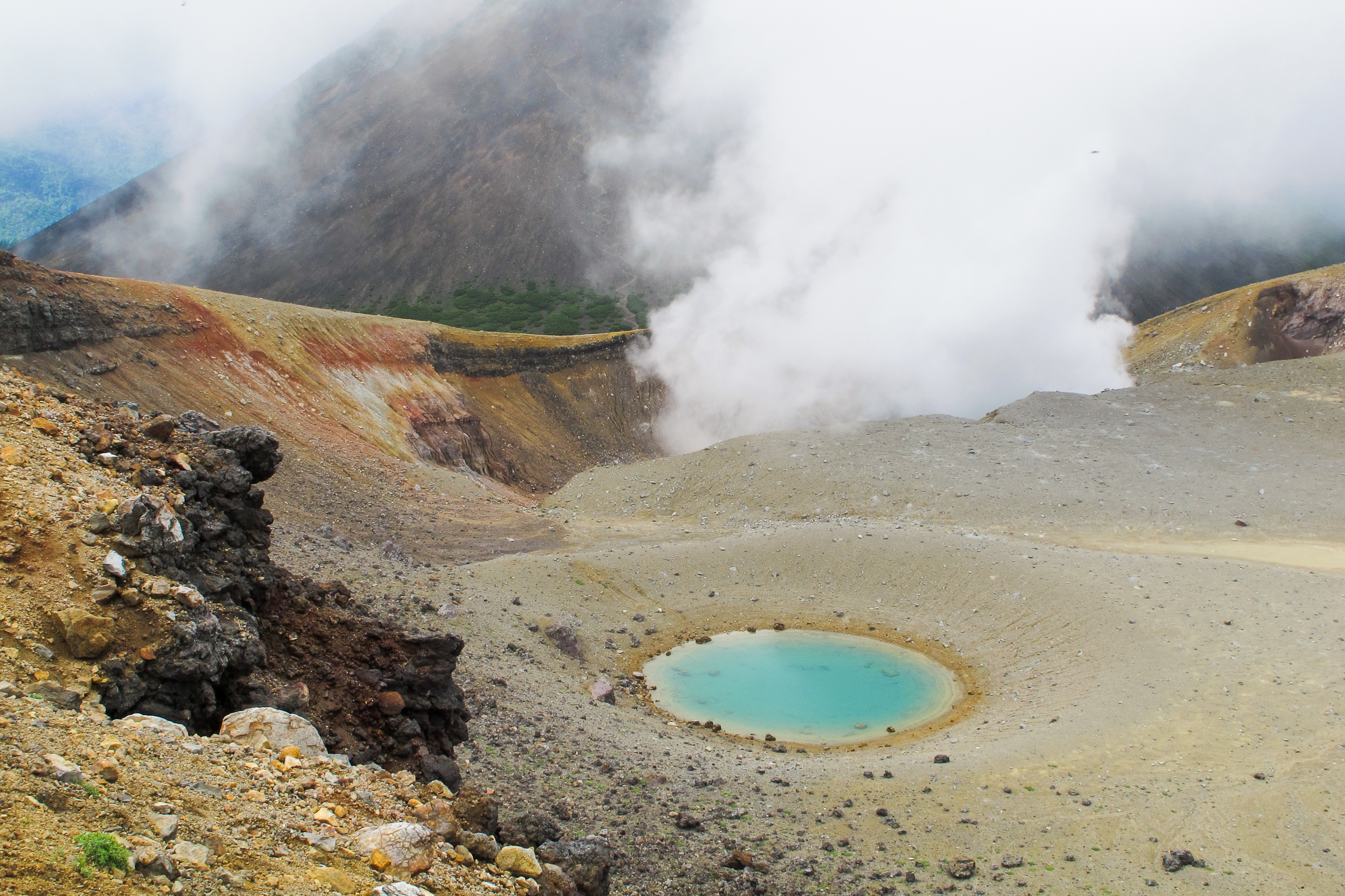 The blue crater pond on Mt Meakan in the Akan–Mashu National Park. Volcanic steam rises in the background.