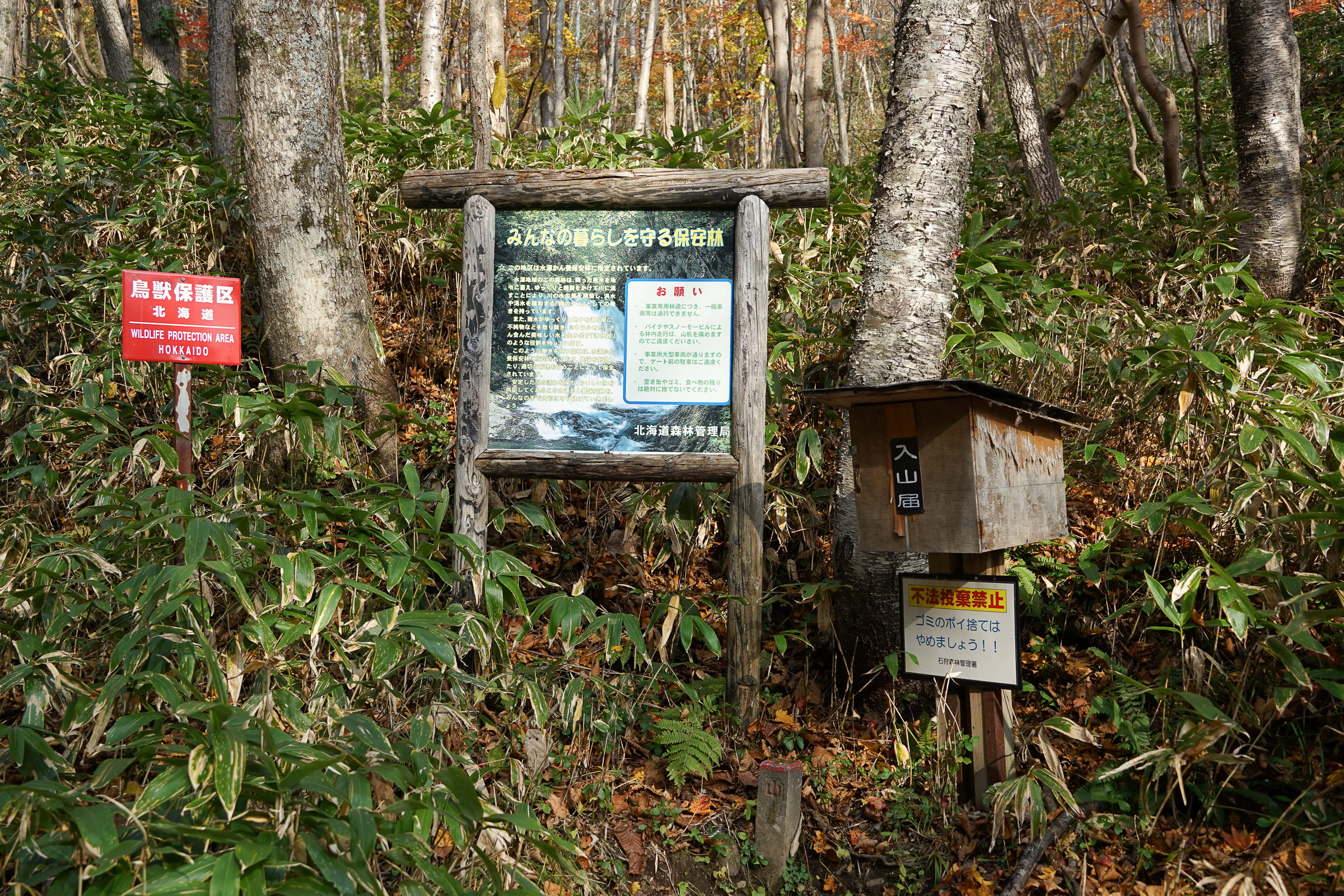A hiking register box and signs at the trailhead of Mt. Monbetsu near Lake Shikotsu.