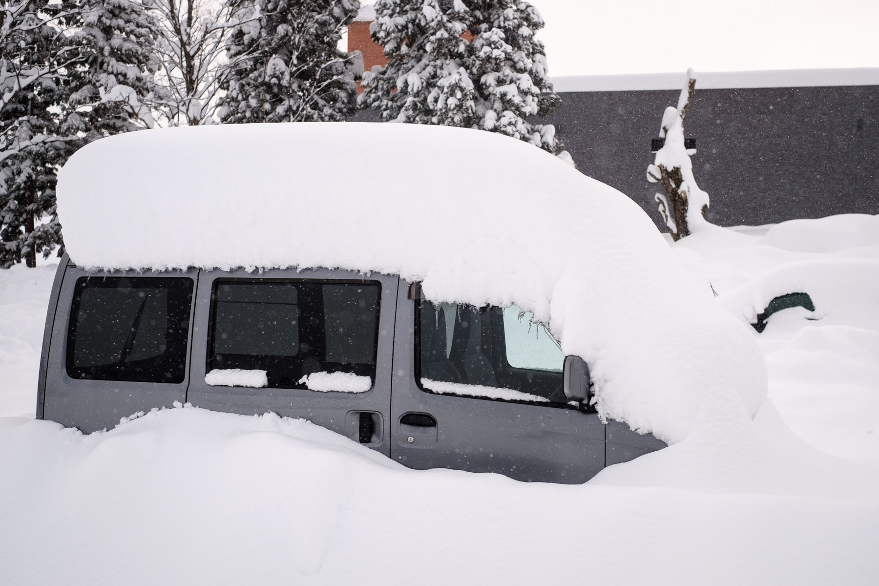 A car sits buried under a metre of snow. Only the windows are visible.