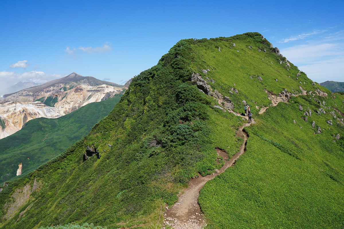 Hikers descending the ridgeline track on the Mt Furano hiking trail in Hokkaido
