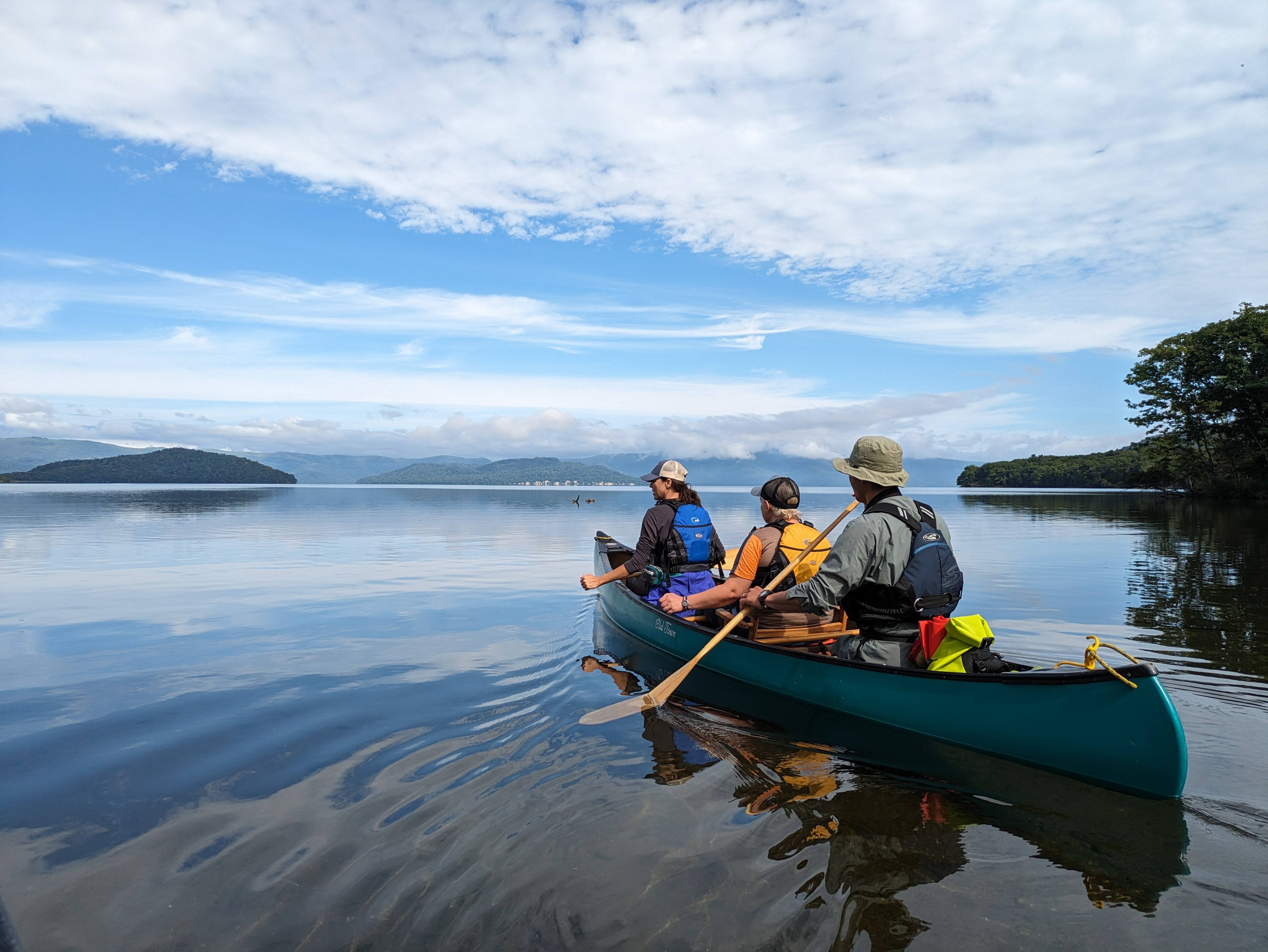 Three enthusiasts in one canoe enjoy Lake Kussharo's brilliant majesty.