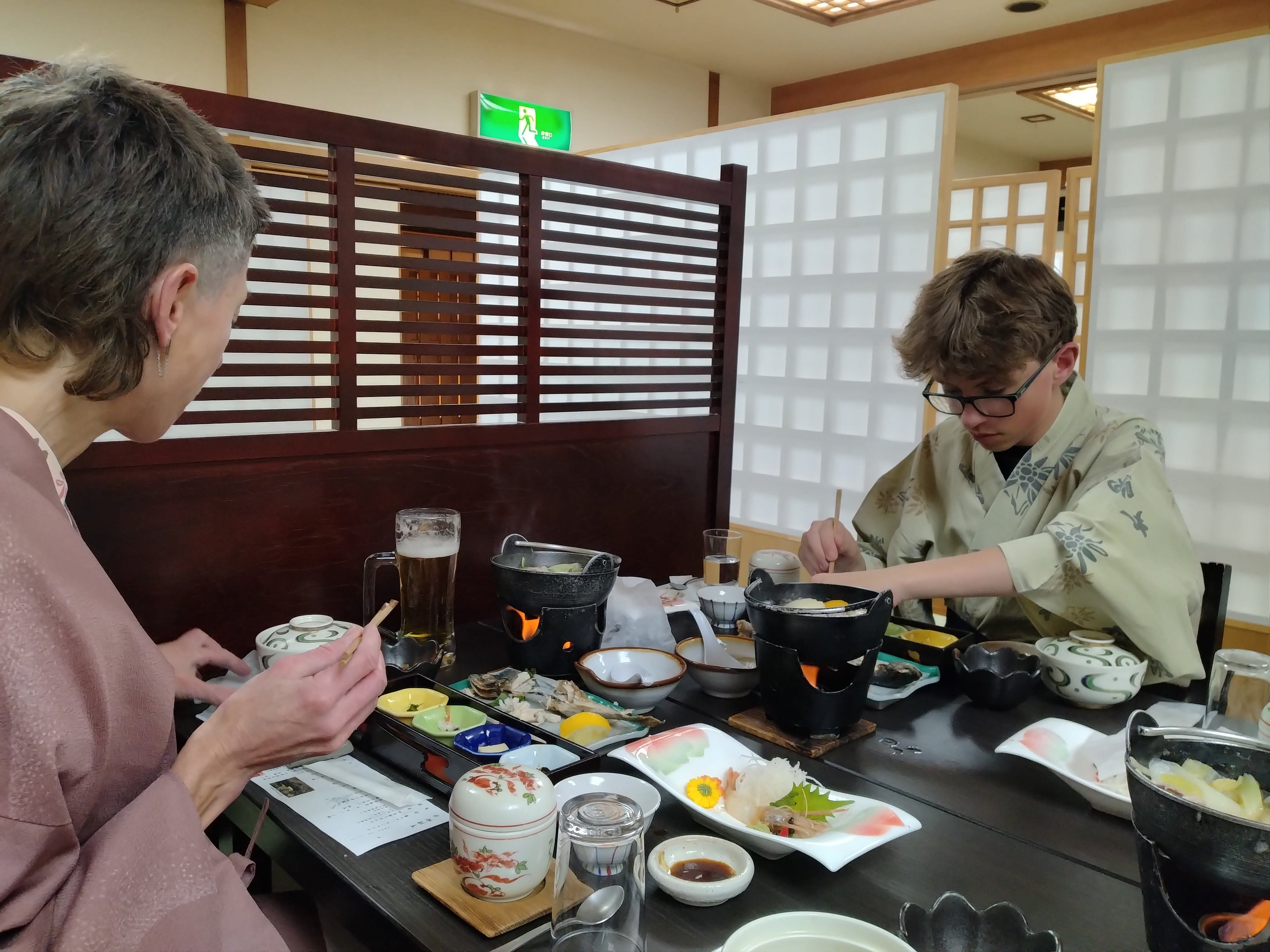 A mother and son enjoy traditional Japanese cuisine while dressed in yukata.