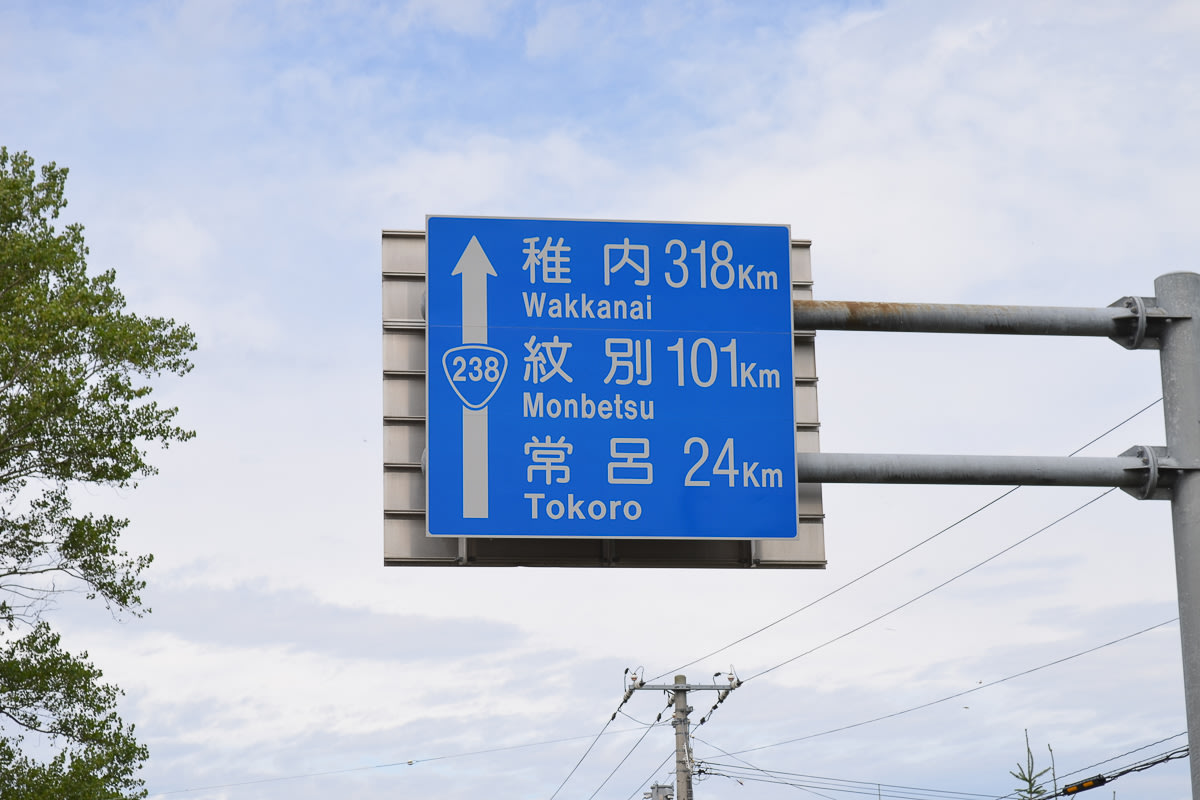 A blue road sign in Hokkaido displays the distances to Wakkanai, Monbetsu and Tokoro