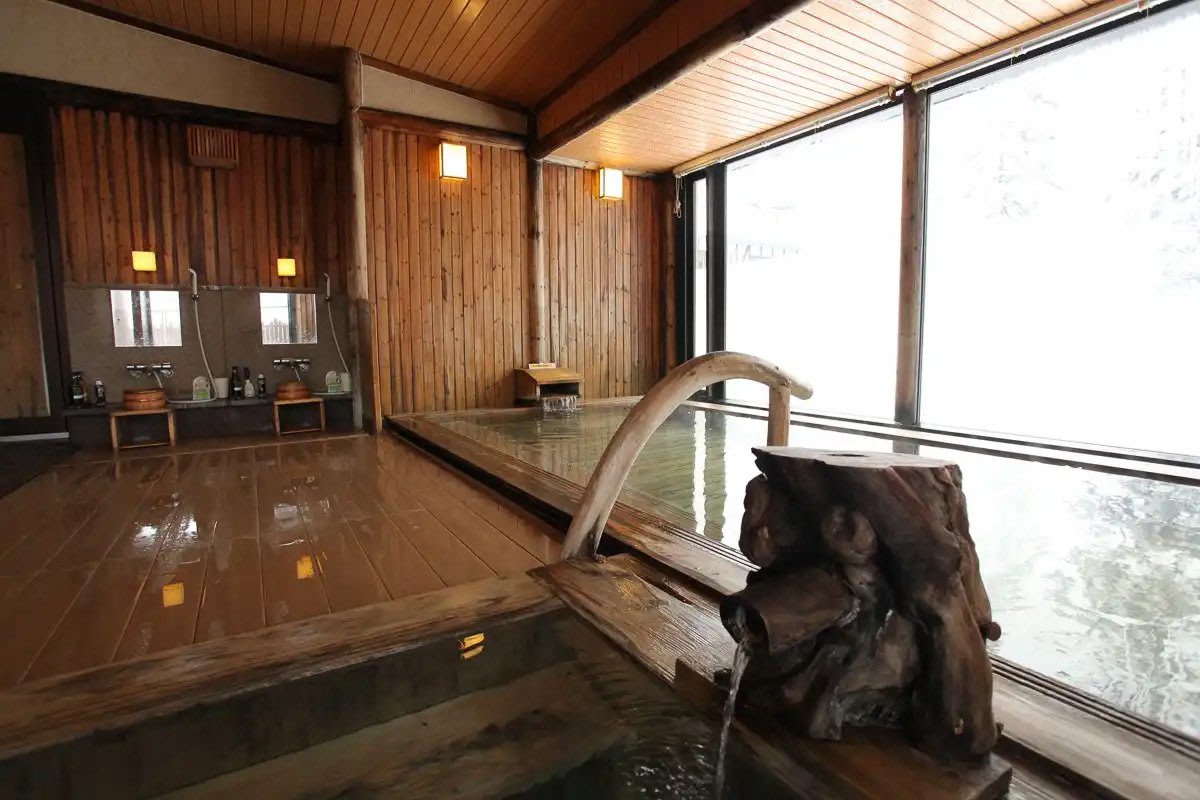 A wooden bath tub filled with water at Asahidake Onsen