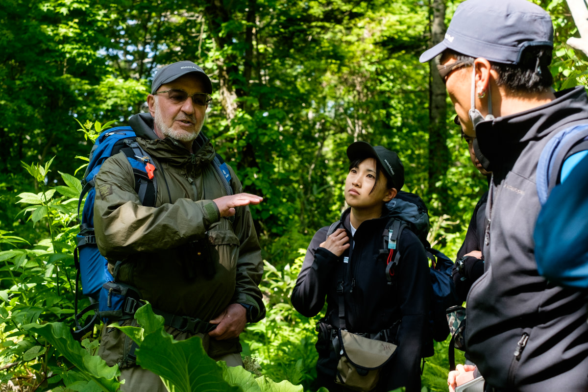 Dr Mark Brazil talks to a group of nature guides in a green forest