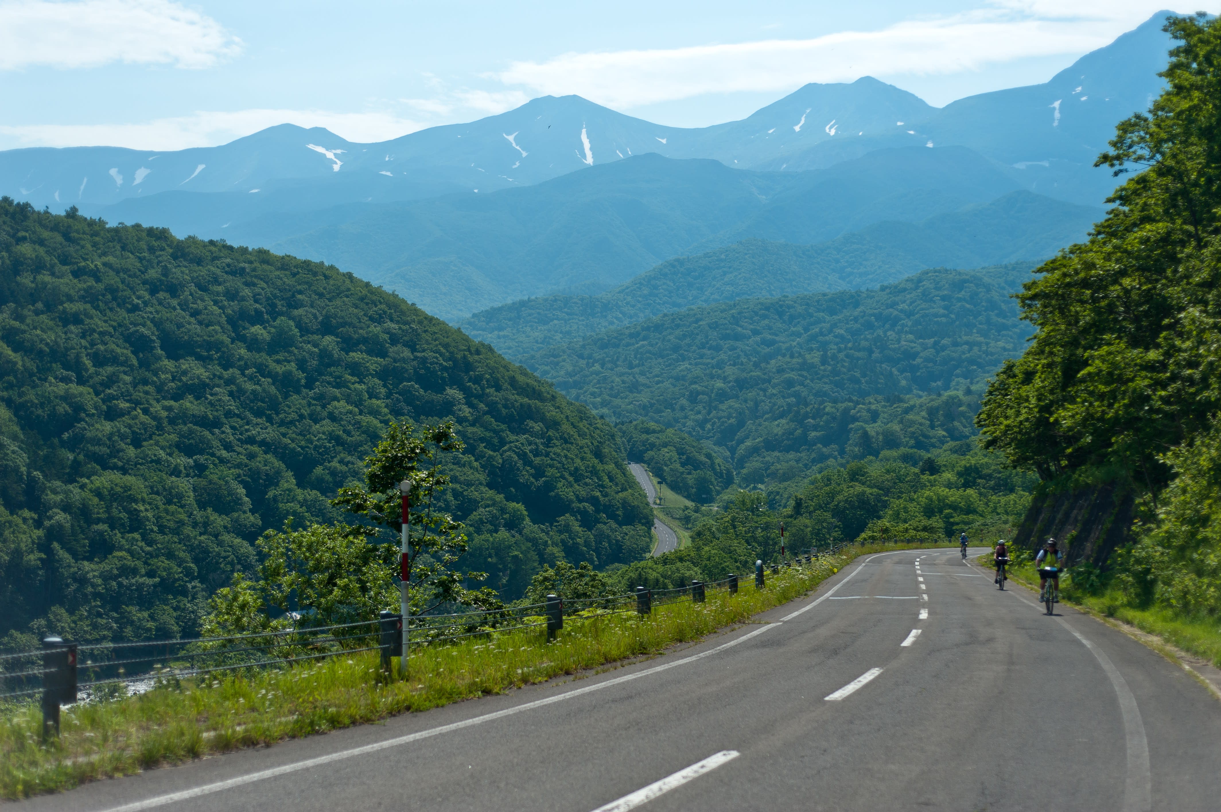 Cyclists climb up Shiretoko Pass in summer.