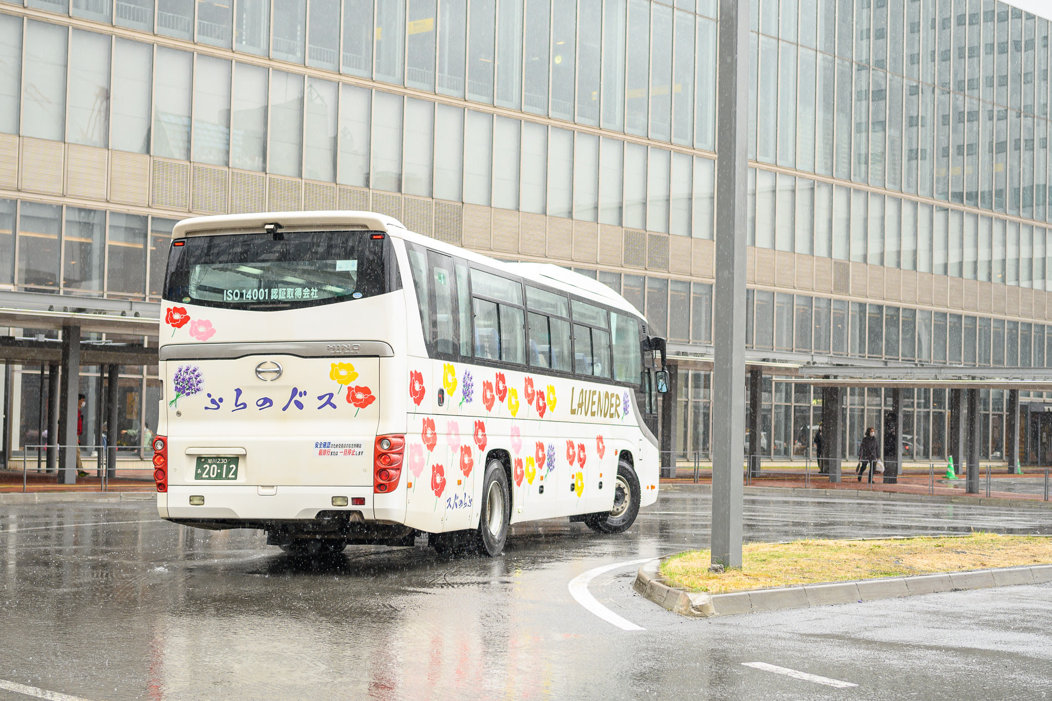 The Lavender Bus, covered in colourful flowers, pulls out of Asahikawa Station. This is the airport bus that runs between Furano and Asahikawa.