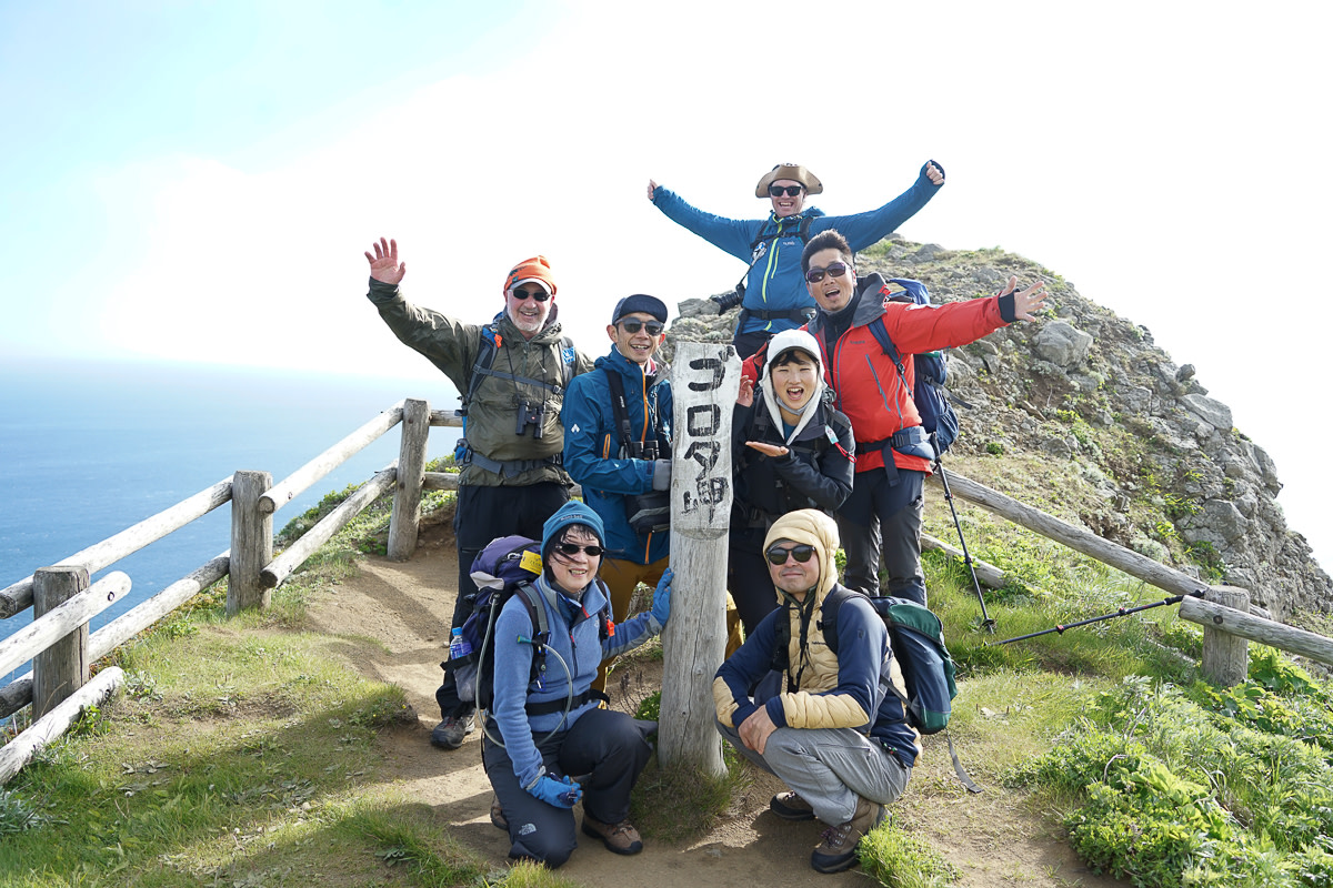 A group of hikers pose at the Cape Gorota viewpoint on Rebun island