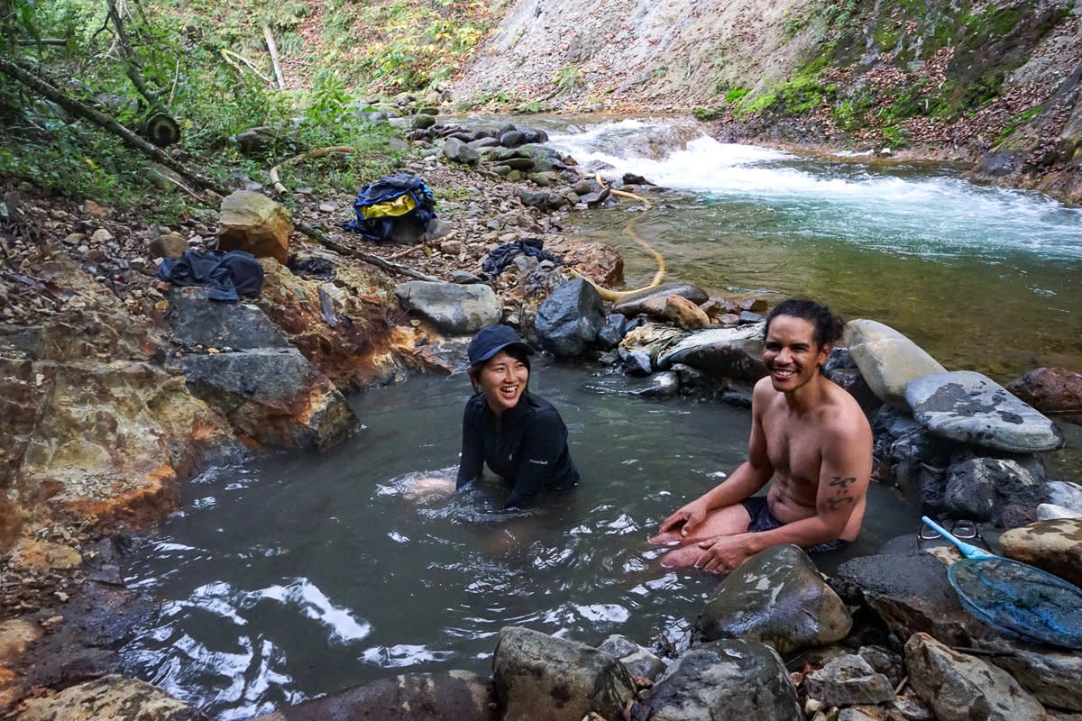 Guides Yuka and Jeremy soaking in natural hot springs