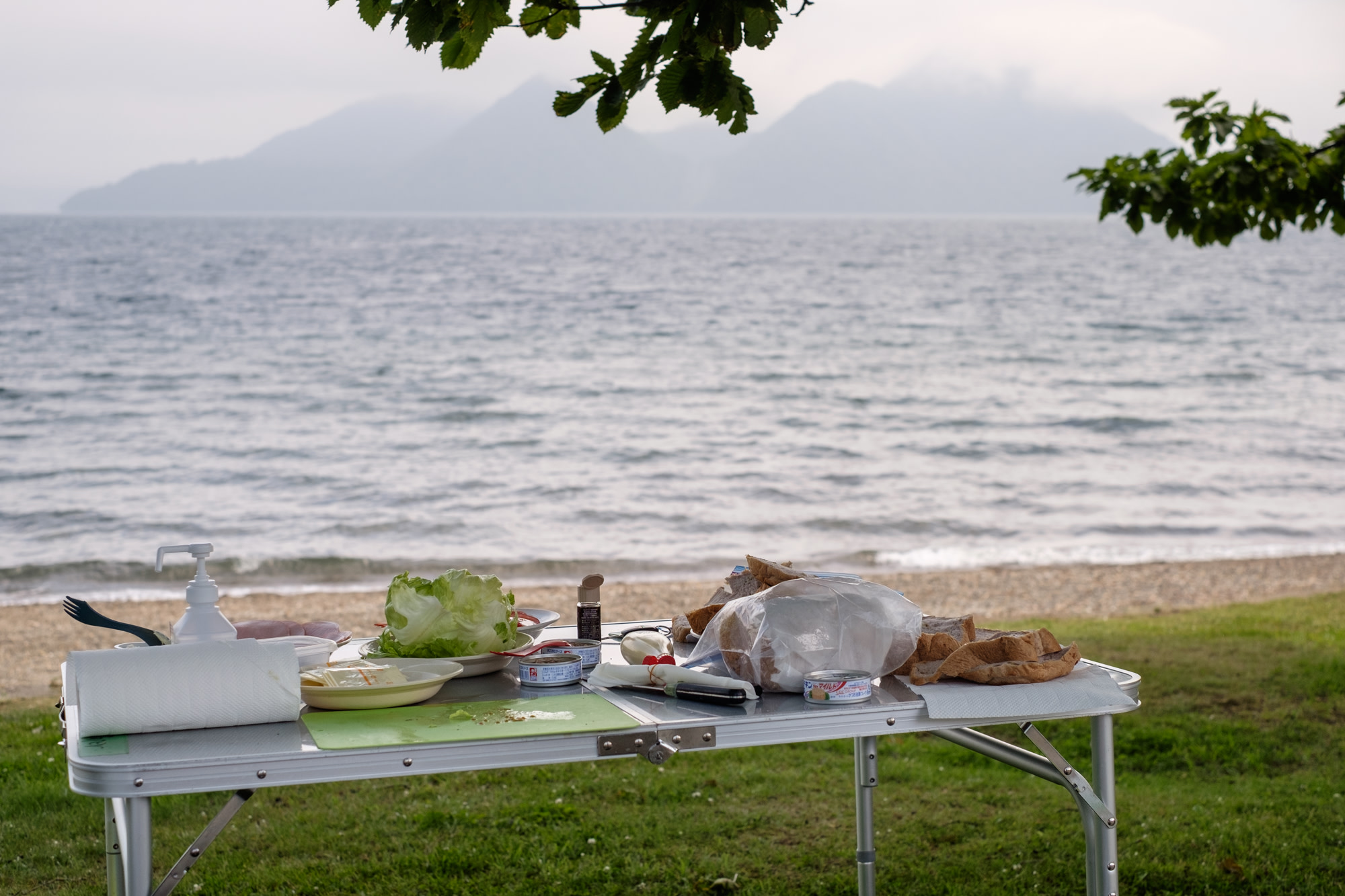 Lunch for a guided cycling tour laid out on a table on the shores of Lake Toya.