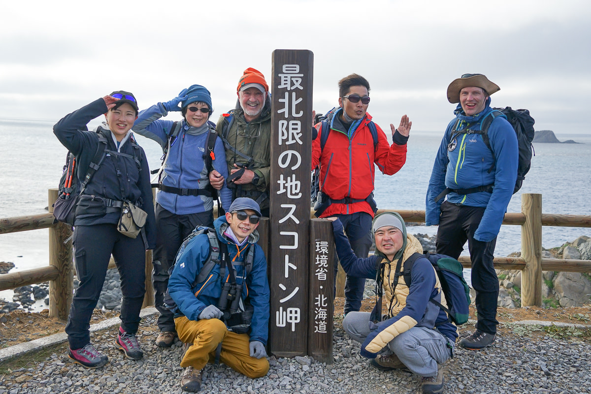 A group of hikers celebrates reaching Cape Sukoton on Rebun island