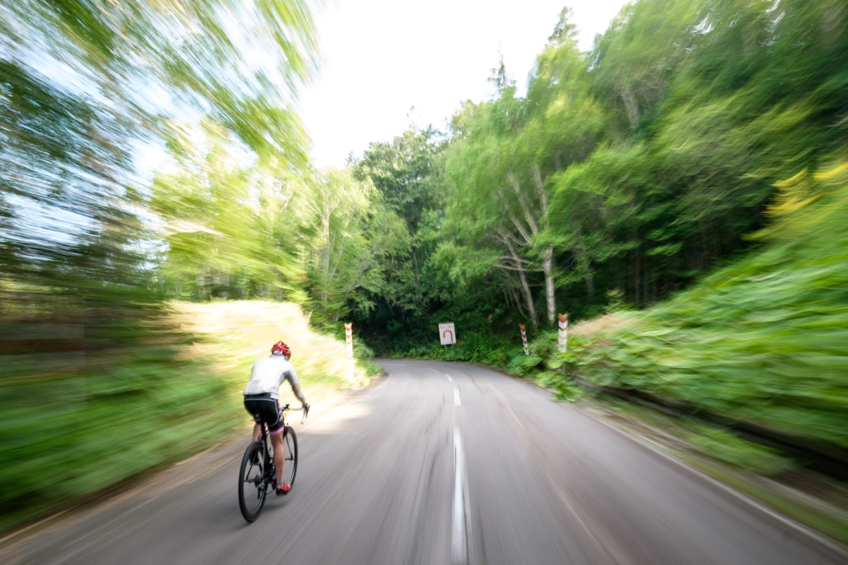A cyclist is blurred as they speed down a hill