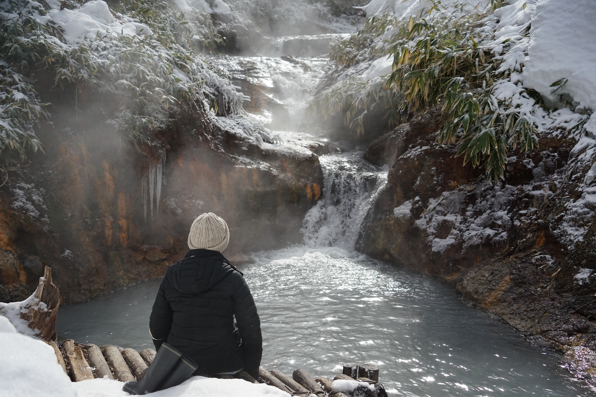 A person enjoying foot-spa at Oyunuma in Noboribetsu Hell Valley in winter.