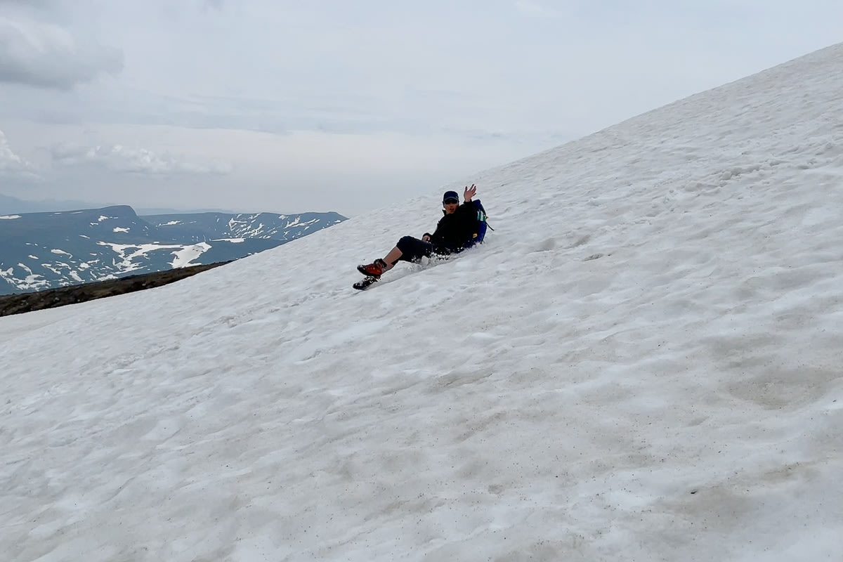 Adventure Hokkaido guide Yasu sliding on snow on Mt Asahidake, Daisetsuzan National Park