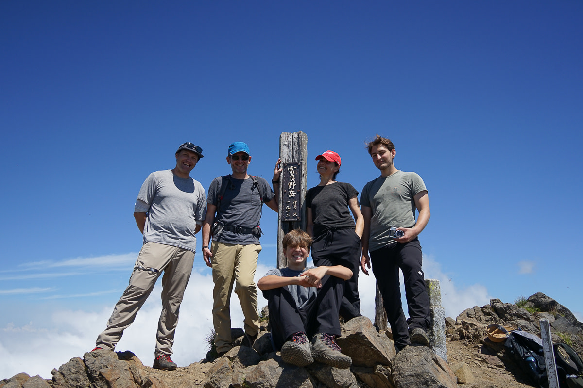 A group of hikers pose for a photo on the summit of Mt. Furano