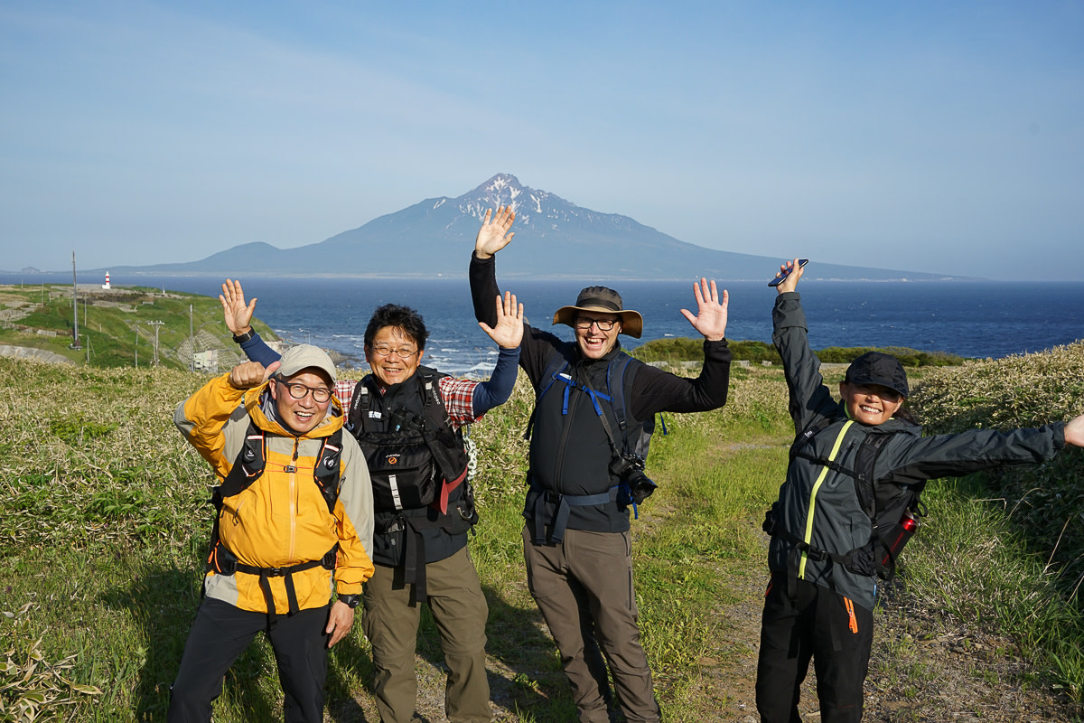 Hikers pose with Mt. Rishiri in the background.