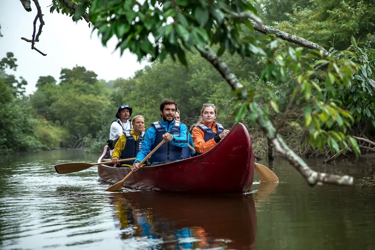 Adventure Hokkaido group enjoys a canoeing trip down a river.