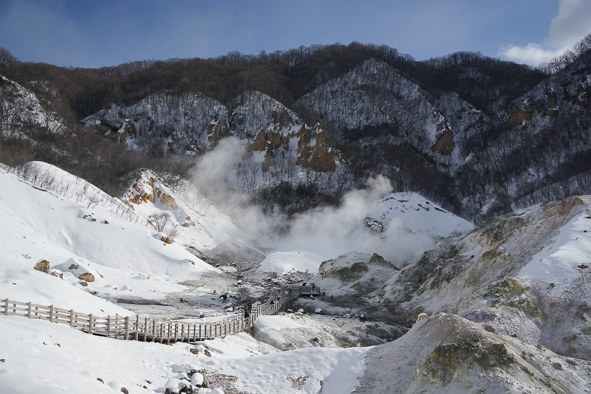 The Jigokudani walkway in Noboribetsu Onsen. There are wooden walkways going down into the valley, where steam rises up.