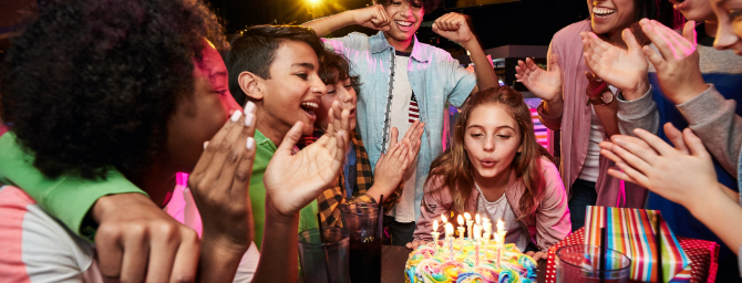 Girl blowing out candles at party