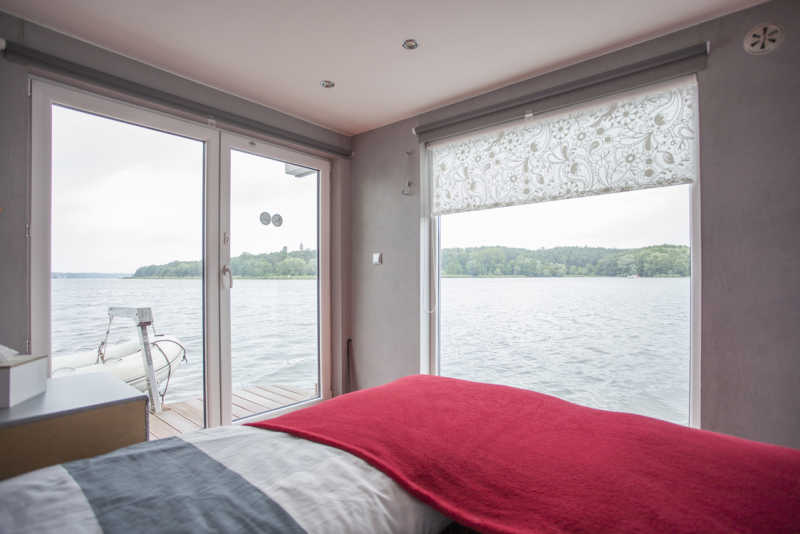 Fensterfront mit Seeblick aus dem Schlafzimmer des Berliner Hausbootes Jaxs