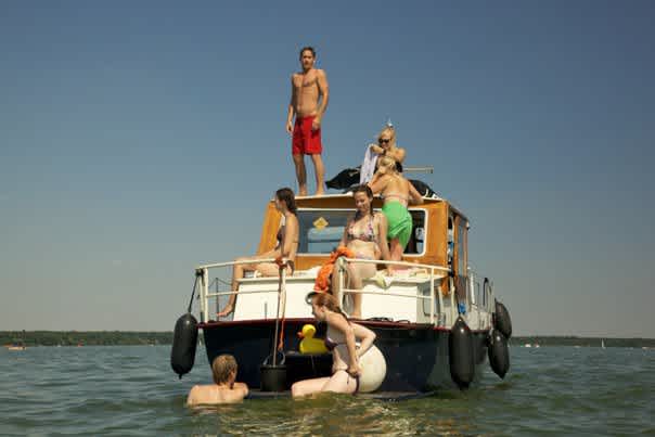 Grillboot Tortuga mit Gästen im Wasser