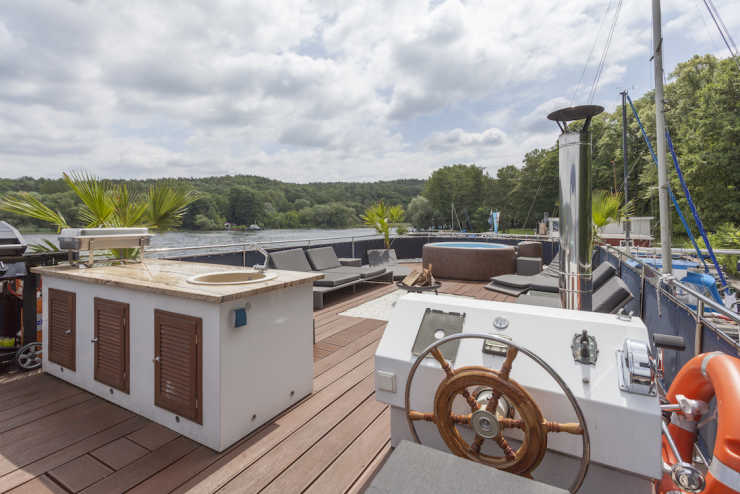 Sun deck of the event boat Jaxs with bar, lounge furniture, whirlpool and steering position