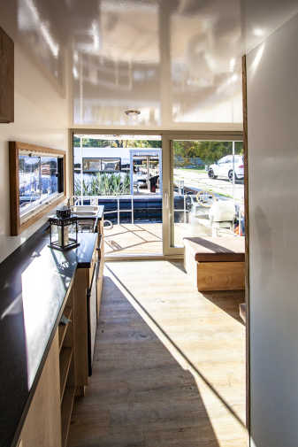 Salon mit Küchenzeile, Holzfußboden und Bugterrasse auf dem Hausboot Flexmobil