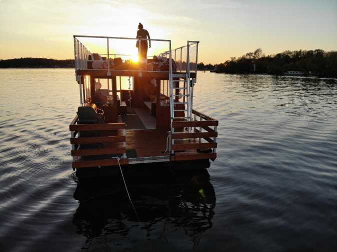 Bug des Partyfloßes Beluga mit Badeplattform bei Sonnenuntergang