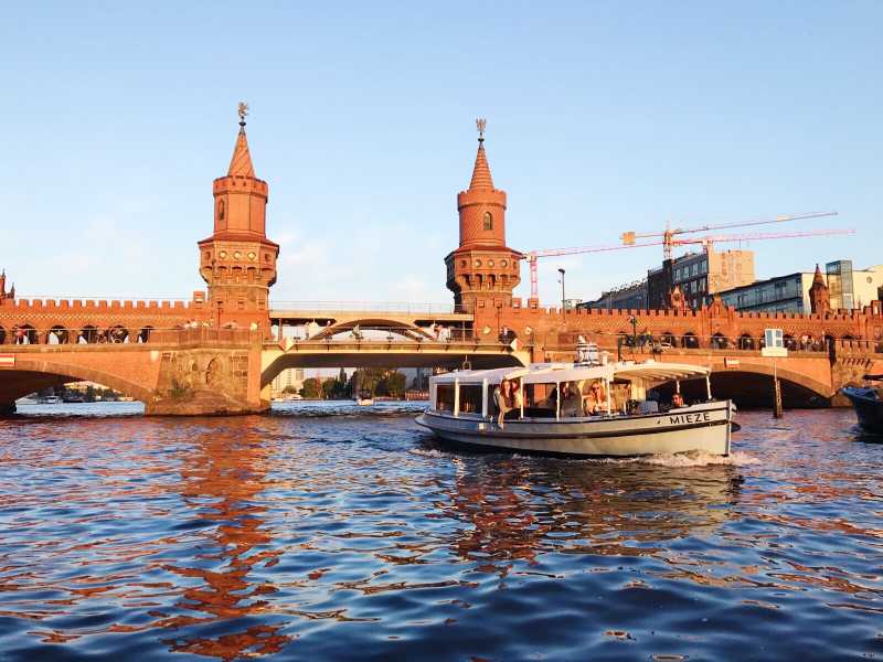 Bootstour mit dem Partyboot Mieze vor der Berliner Oberbaumbrücke bei niedriger Sonne