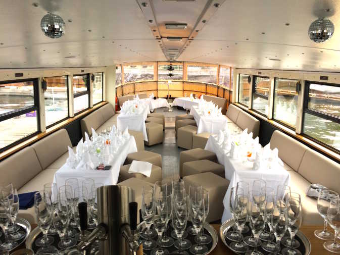 Tables with tablecloths and champagne glasses on the event ship Arcona