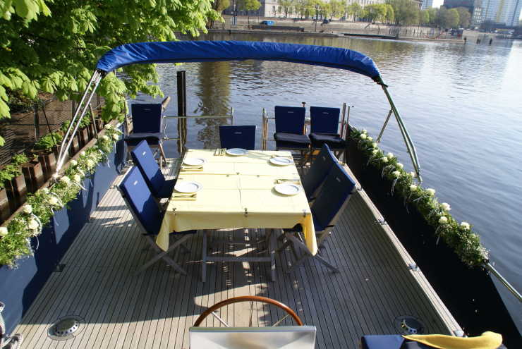 Sonnendeck mit Esstisch und Stühlen auf dem Motorboot Löcknitz in Berlin