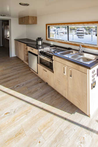 Large kitchenette and wooden floor on the Flexmobil houseboat in Berlin