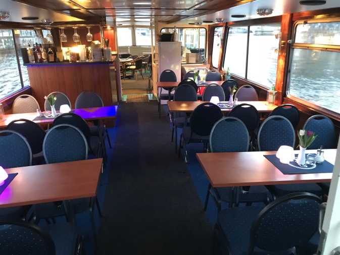 Salon mit Tischen und Stühlen auf dem Partyschiff La Belle