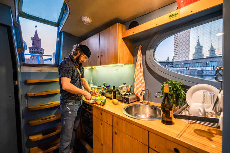 Man cooks in the kitchen of the Rossi houseboat