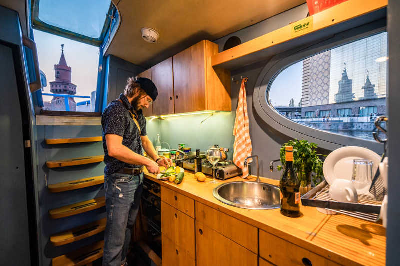 Mann kocht in der Küche des Hausbootes Rossi