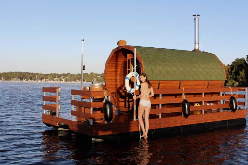 Saunafloß auf dem Wannsee mit einer jungen Dame im Bikini auf der Badeleiter