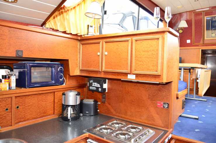 Kitchen with stove, coffee machine and microwave on the Maxima houseboat