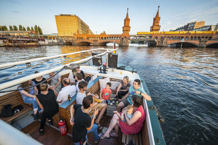 Open stern area of ​​the ship Josi with party guests in front of the Oberbaum Bridge