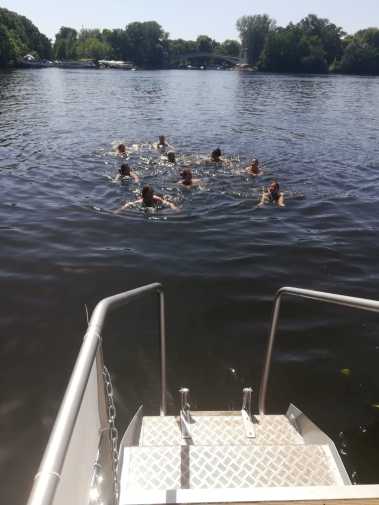 Badeleiter auf dem Partyboot Ian Fraser mit Gästen im Wasser auf einer Badetour