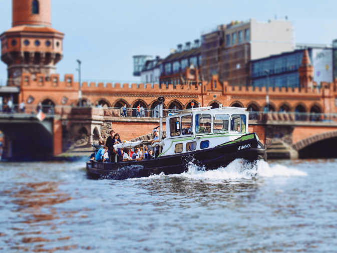 Partyboot Jimmy von Berlin Bootsverleih auf einer Bootstour vor der Oberbaumbrücke mit feiernden Gästen