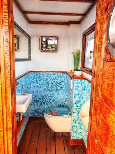 Luxurious bathroom with toilet, urinal and hand basin on the Rib-Eye raft in Berlin