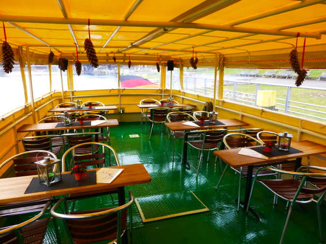 Salon mit Tischen und Stühlen im Heck des Schiffes Heiterkeit
