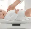 Bebé siendo pesado por médico